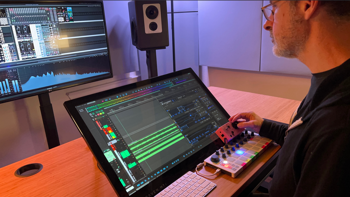 Bryan Leach adjusting a desktop controller at his sound-design workstation.